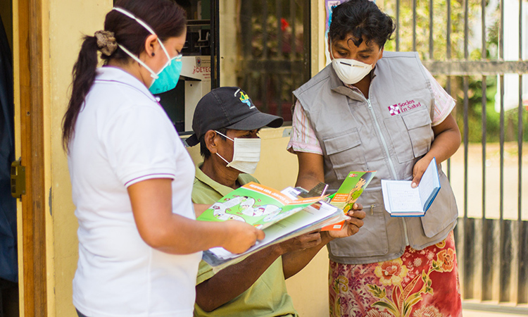 Diego,* a patient with TB, receives advice and treatment from Verónica Quispe, a community health worker, and Yecela Rodríguez, a field technician, at the Punchauca Health Center in Carabayllo, Peru. *Name has been changed. (Photo by William Castro Rodríguez / Partners In Health)