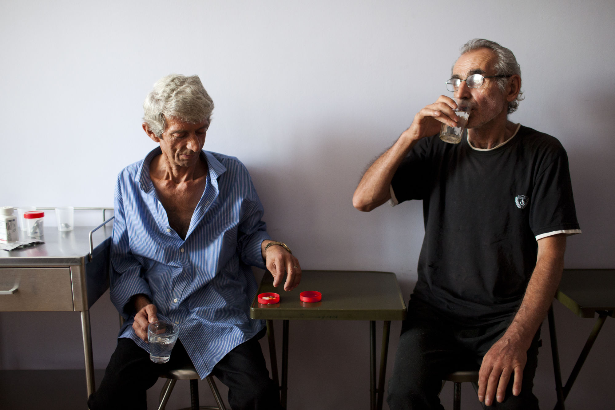 Пациенты Ахмед Ходжава (слева) и Нугзар Папашвили (справа) принимают таблетки под непосредственным наблюдением медперсонала в стационаре Национального центра туберкулеза и заболеваний легких в столице Грузии Тбилиси